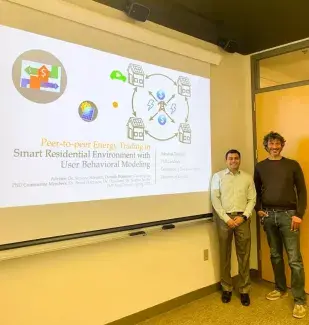 Dr. Silvestri standing with a student in front of a presentation slide