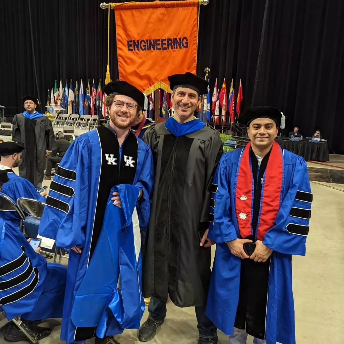 Simone Silvestri with two students at UK's graduation in their cap and gowns.